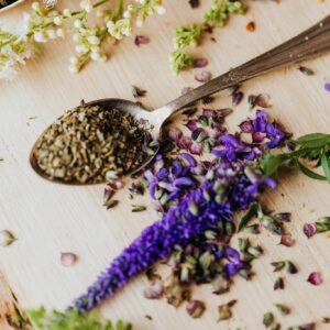 Edible Flowers Beside Spices and Herbs on Wooden Board